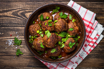 Meatballs in tomato sauce on wooden table top view. 