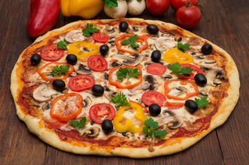 Pizza with ham, pepper and olives. Delicious italian pizzas on a wooden background