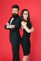 Formal fashion and elegant clothes. Luxury fashion boutique. Fashion clothes shop. Official event. Couple man in tuxedo and elegant girl. Man bearded hipster and woman in formal dress red background
