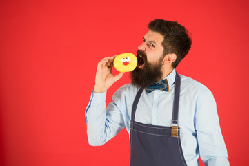 Having snacks. Diet and healthy food. Baker eat doughnut. Chef man in cafe. Calorie. Feel hunger. Bearded baker. Bearded man in apron. baker hold donut. Funny hipster. Professional baker