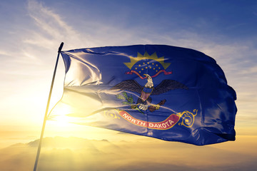 North Dakota state of United States flag waving on the top sunrise mist fog