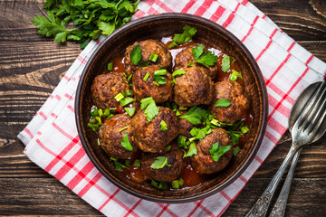 Meatballs in tomato sauce on wooden table top view. 
