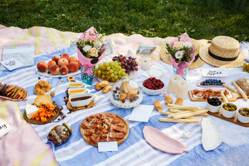 Summer picnic blanket with tasty food and snacks on it. Summer weekends