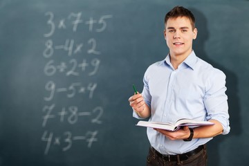 Young male teacher   standing with book