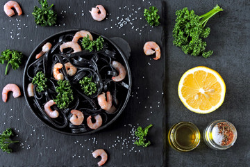 Black noodles with cuttlefish ink with shrimps. Black food. Food trend 2019.