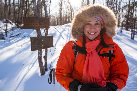 A woman all smiles while snowshoeing along the Black Cap Mountain Trail at the junction with the summit loop in the Green Hills Preserve near North Conway, New Hampshire.