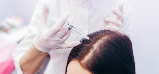 Fototapeta premium Young woman with hair loss problem receiving injection, close up