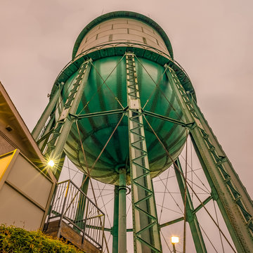 low angle photography of teal and white water storage tank