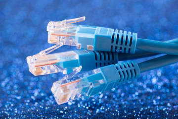 Three network cables over blue sparkles background  - obrazy, fototapety, plakaty