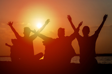 Group of teenagers and child feeling free at sunset