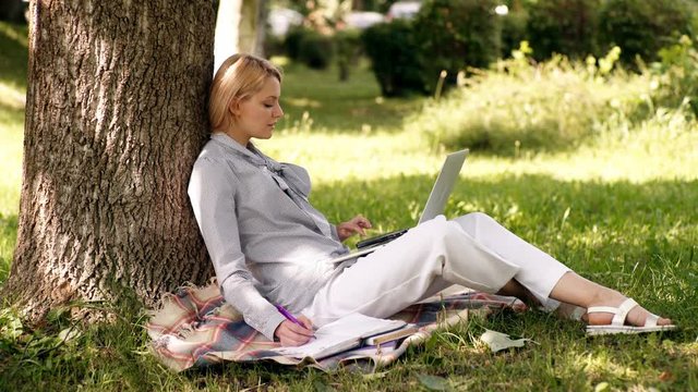 Education technology and internet concept. Natural environment office. Work outdoors benefits. Woman with laptop work outdoors lean tree. Minute for relax. Girl work with laptop in park sit on grass.