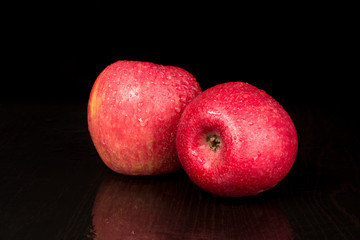 Fototapeta na wymiar Two ripe apples lie next, wet apples, black background
