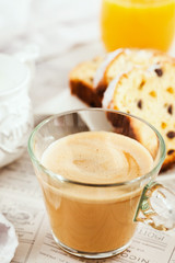 Continental breakfast table with cup of hot  coffee with milk, cakes and orange juice