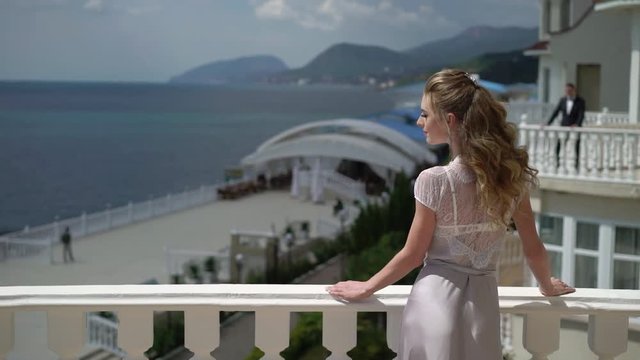 Man and woman staying on different balcony and sends air kiss. Couple of lovers or newlyweds