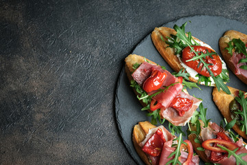 Traditional Italian bruschetta with dried tomatoes, prosciutto and arugula.