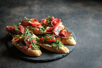 Traditional Italian bruschetta with dried tomatoes, prosciutto and arugula.