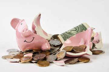 Broken piggy bank with coins money isolated on white background, close-up