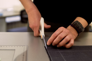 Master cuts fabric. Nesting. Suiting fabric marked with white chalk. Cutting and sewing
