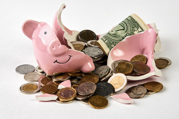 Broken piggy bank with coins money isolated on white background, close-up
