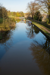 A section of the Leeds to Liverpool canal on a bright and clear autumn morning, two narrow boats in...