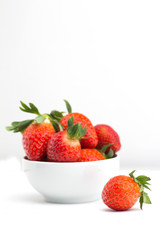 strawberries in a bowl isolated on white background