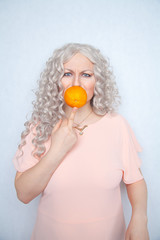 chubby cute blonde hates oranges fruits. pretty woman standing on white studio solid background alone. 