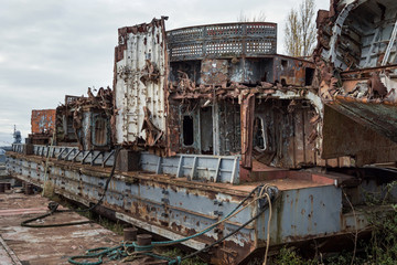 Huge rusty pieces of decommissioned marine ship that was cut and left on the shore.