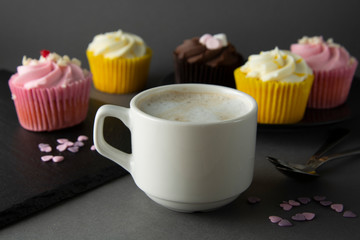 Chocolate cupcakes and coffee , breakfast with colorful cupcakes. Gray background. Sweet dessert.
