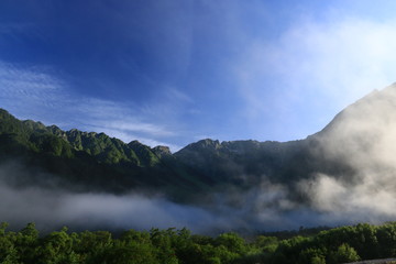北アルプス　神々しい上高地の朝の風景　雲と岳沢と穂高連峰と