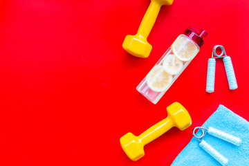workout with bars, bottle of water and wrist builder red background top view mockup