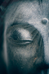 Fototapeta premium Soft spiritual sun rays on a buddha face close up shot. Buddhist religion concept idea