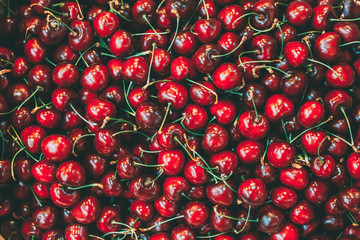 Fresh red ripe sweet cherry berries forming background on farmers market