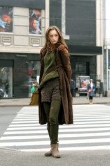 Obraz premium Tall slim girl crosses the road at a crosswalk