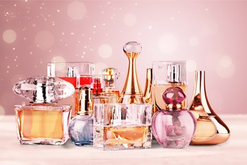 Aromatic Perfume bottles on white wooden desk at wooden background