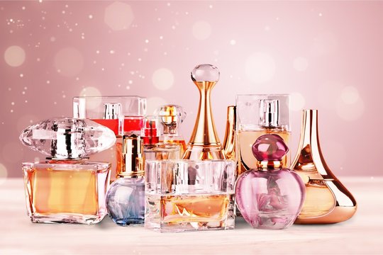 Aromatic Perfume bottles on white wooden desk at wooden background