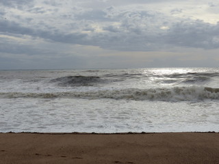 Fototapeta na wymiar Wolken, Wellen und Strand im Regen
