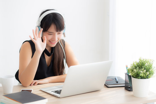 Beautiful young asian woman wear headphone smiling say hello using chat video call on laptop computer, girl relax enjoy listening music online, education learning, communication and lifestyle concept.