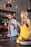 Helpful husband taking some spices while cooking dinner with his woman