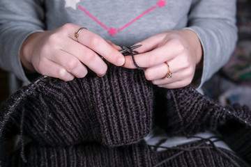 image of a girl knitting on metal knitting needles