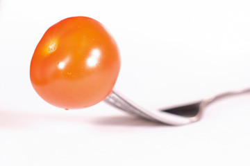 image of a tomato pinned on a fork