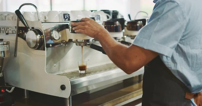 Attractive young barista preparing delicious coffee, barista pouring espresso shot, coffee shop lifestyle