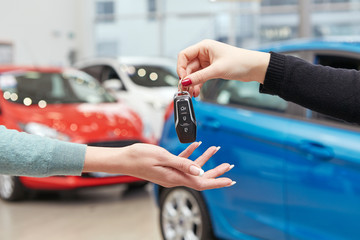 Drive safe. Cropped closeup of a female car owner receiving car keys from the car dealer manager