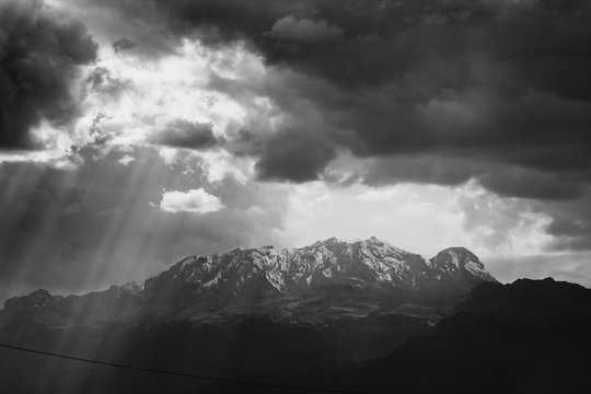 black and white photo of the iztaccihuatl summit covered by snow, ray of lights trough clouds © CMH