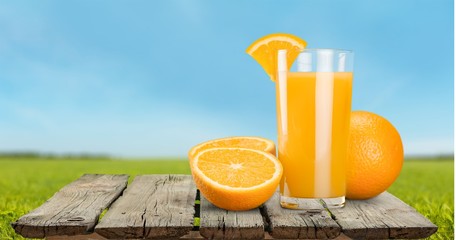 Glass of delicious orange juice on table