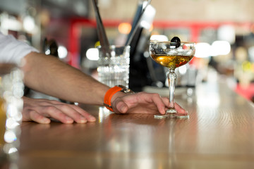 Working quickly.  Closeup shot of bartender offering a cocktail.