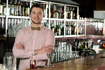 Engaging others. Well-dressed bartender smiling and ready to take orders.