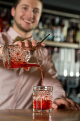 Yon need to drink. Smiling bartender providing hospitality to the clients.