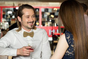 Take your chance. Young mustached males talking to beautiful females at the bar.