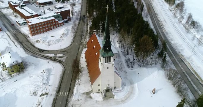 Lapland church, C4k aerial, orbit, drone shot, around the cathedral and Kemijarvi village, on a overcast, winter day, at the arctic circle, in Lappi, north Finland