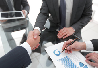 Two businessmen handshaking, congratulating on promotion. Close